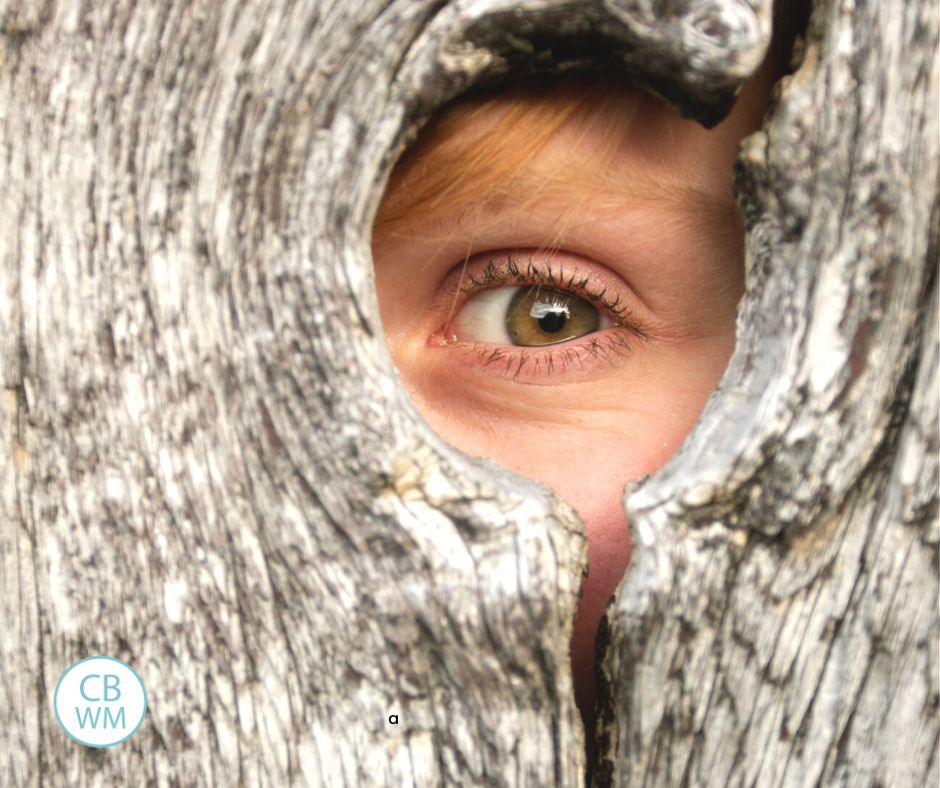 Child looking through hole in fence