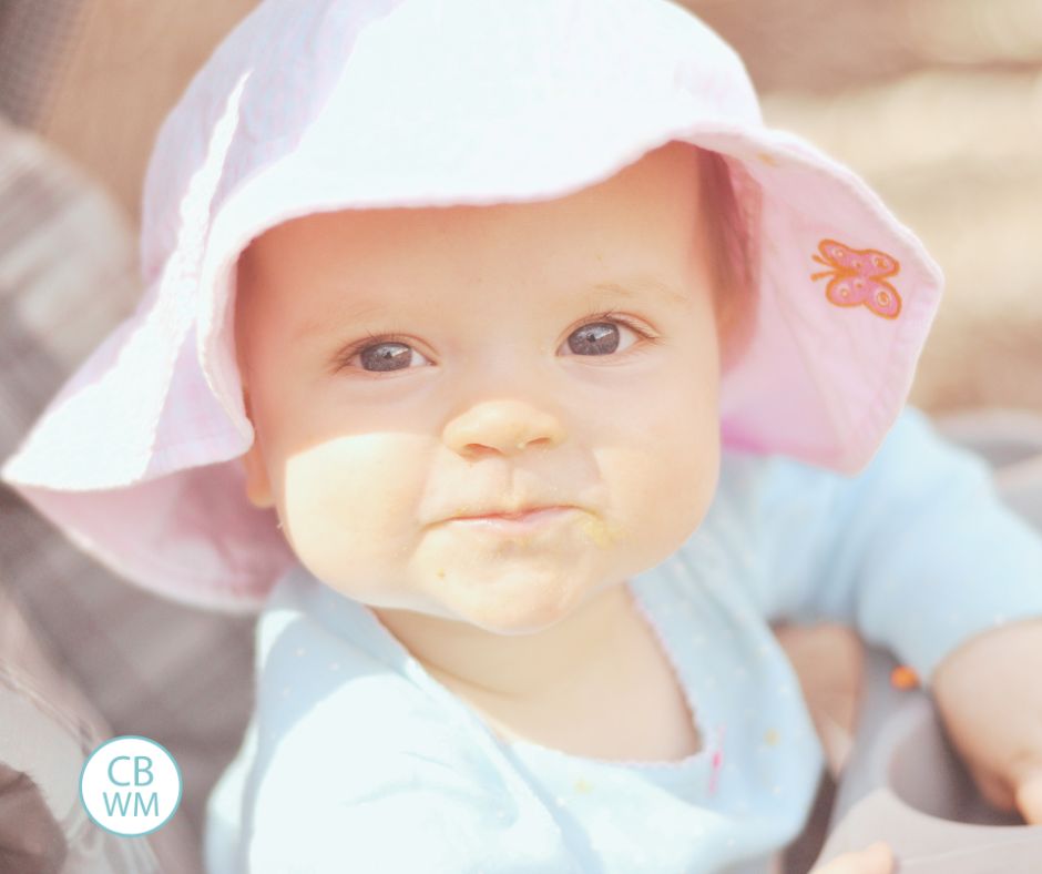 36 week old Brinley wearing a sun hat and looking at the camera