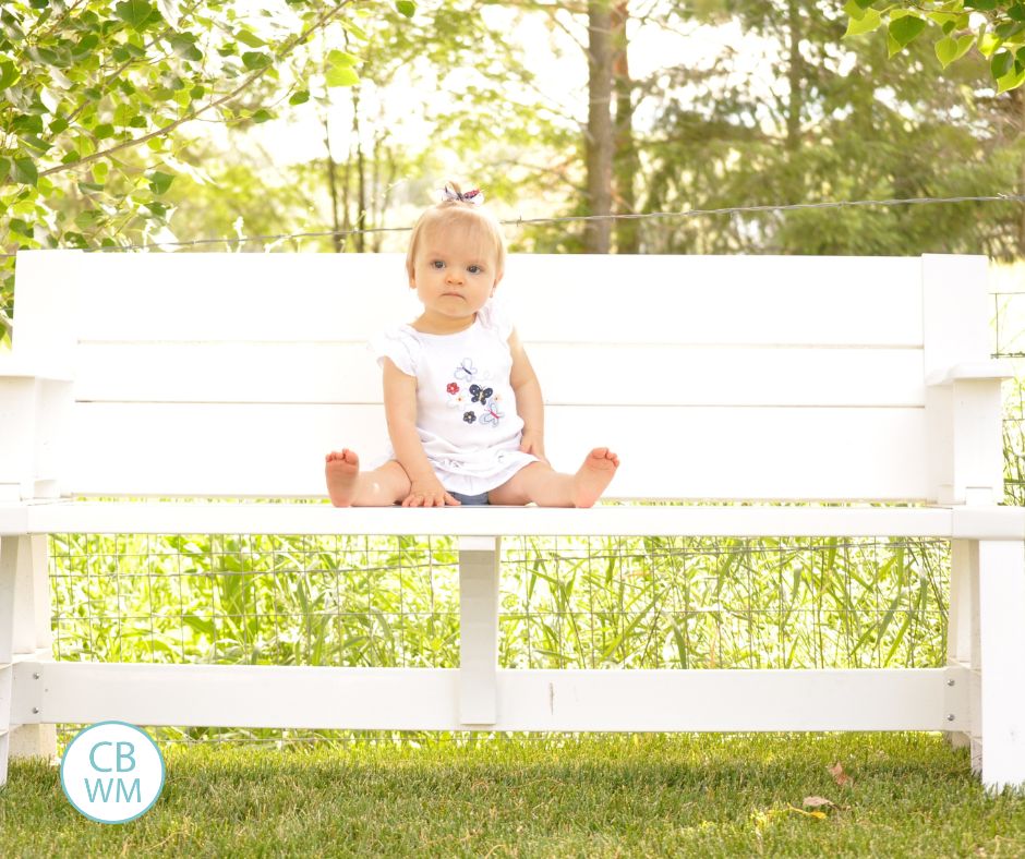 49 week old Brinley sitting on a bench