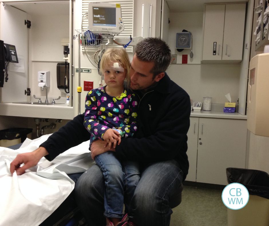 McKenna sitting on her dad's lap in the ER