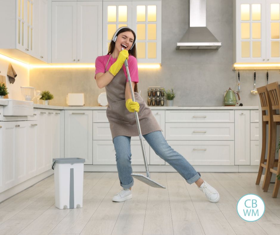 Woman happily cleaning her kitchen floor