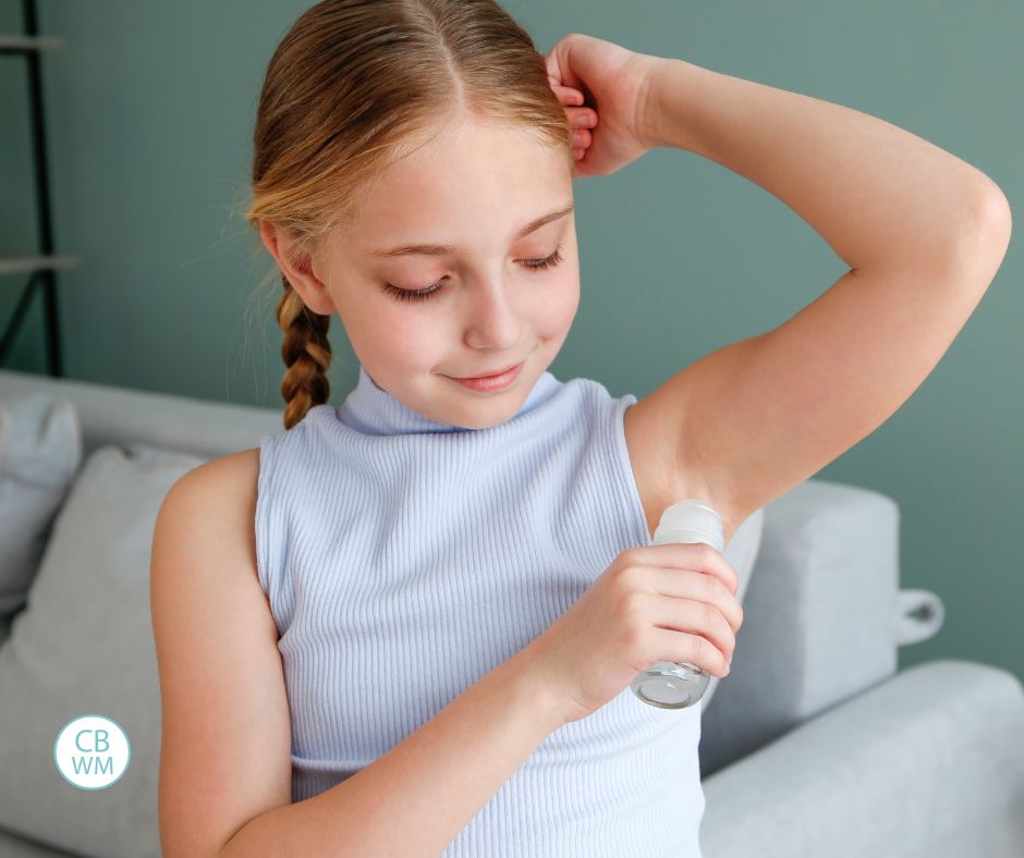 Child putting on deodorant