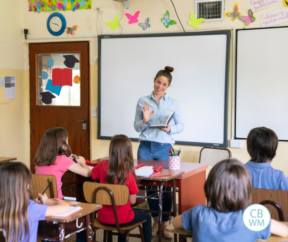 teacher standing in front of the class teaching