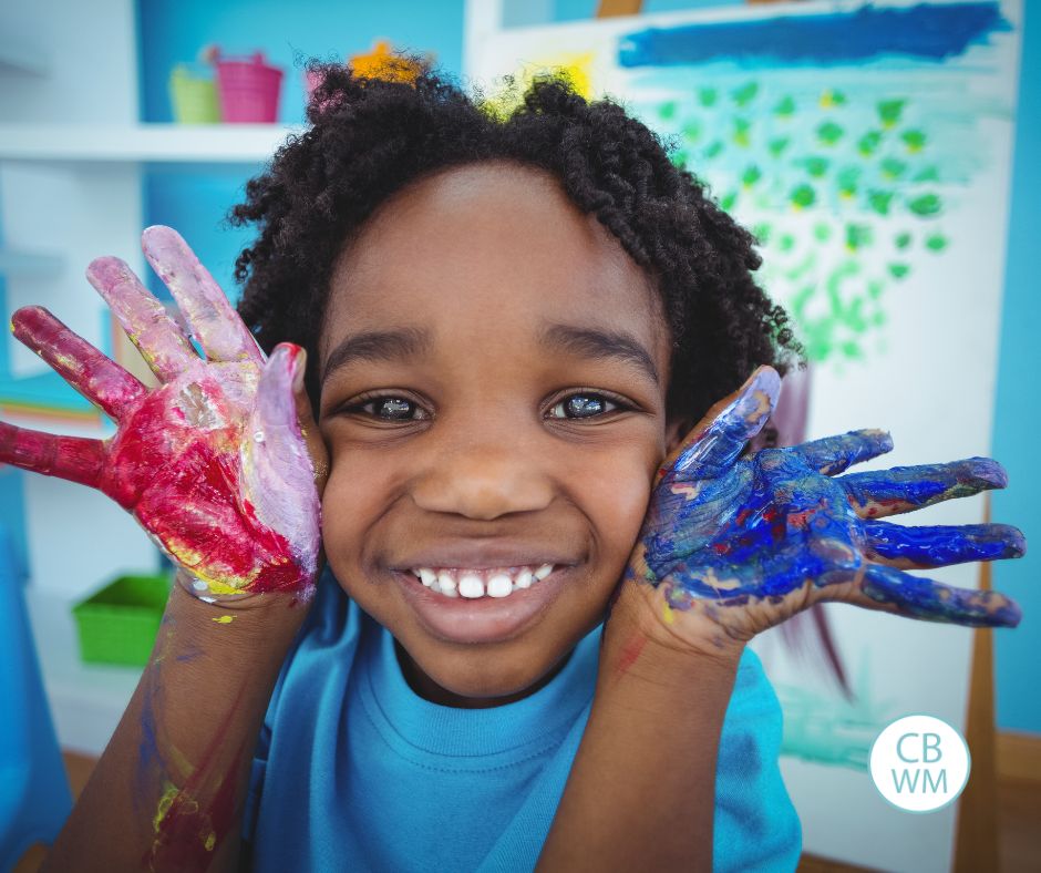Child doing art with hands painted