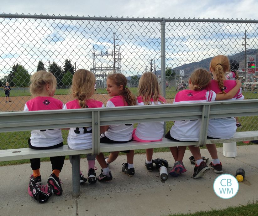Team of softball players sitting on a bench