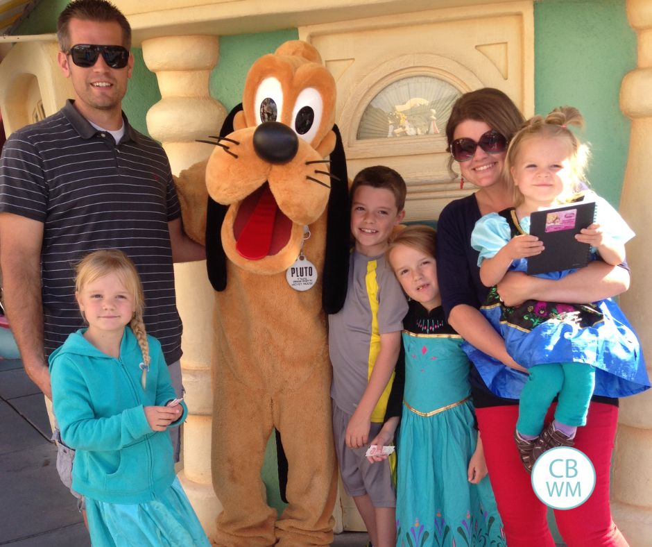 Plowman family posing for a photo with Pluto in Disneyland