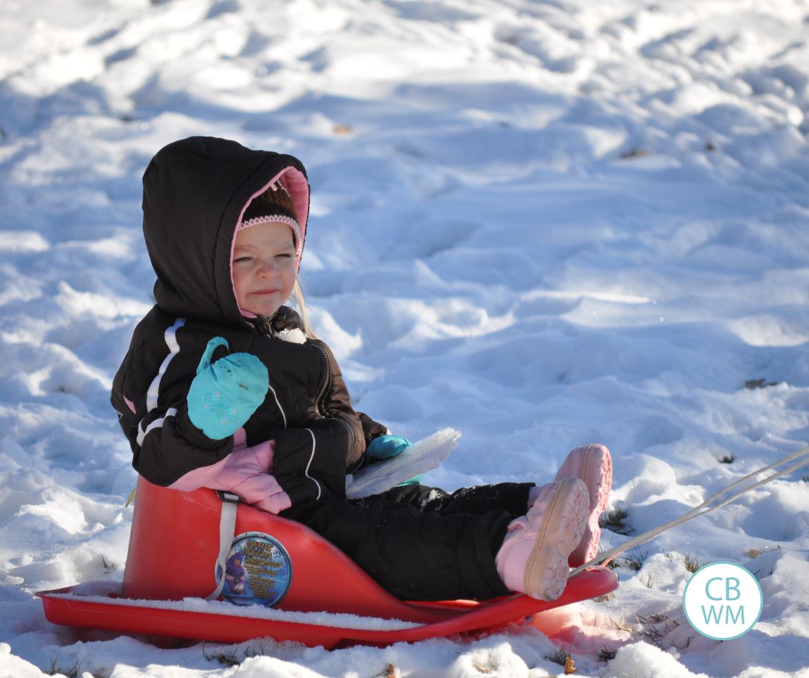 Brinley on a sled in the snow