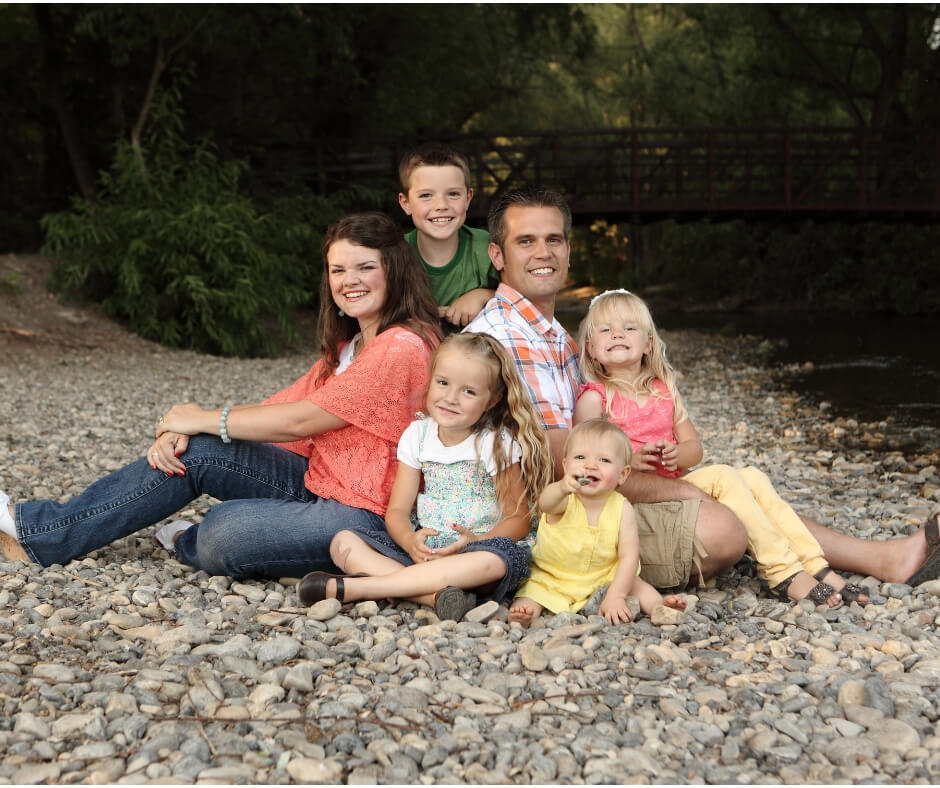 Family of 6 sitting on river rock