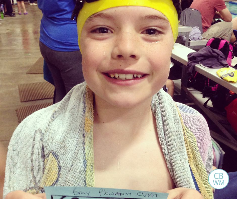 Brayden holding up a coupon after winning his heat in a swim meet