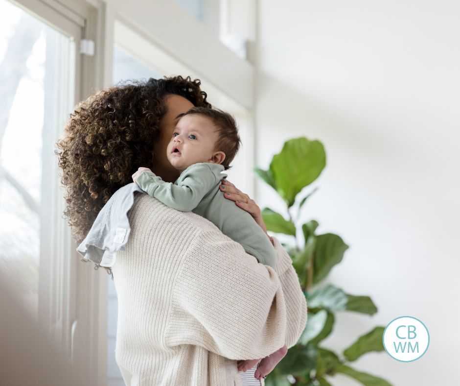 Mom holding a baby over her shoulder who is awake 