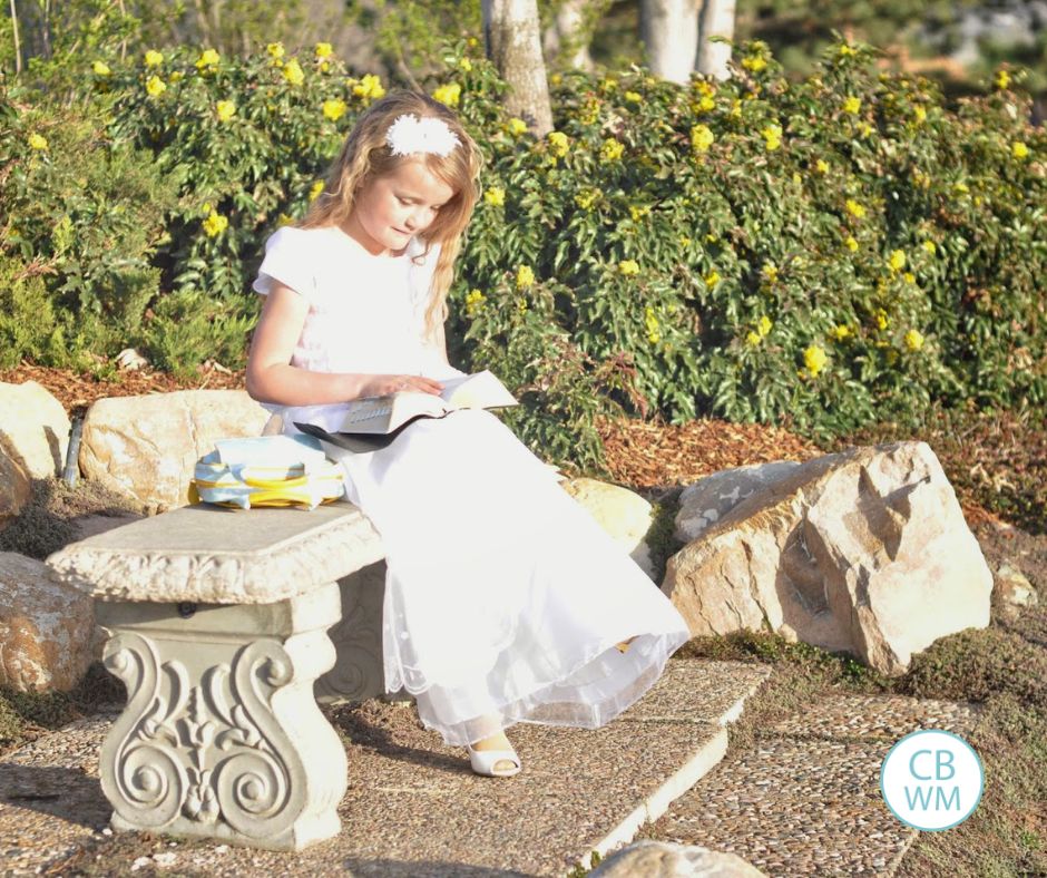 Kaitlyn wearing a white dress, sitting on a bench reading her scriptures