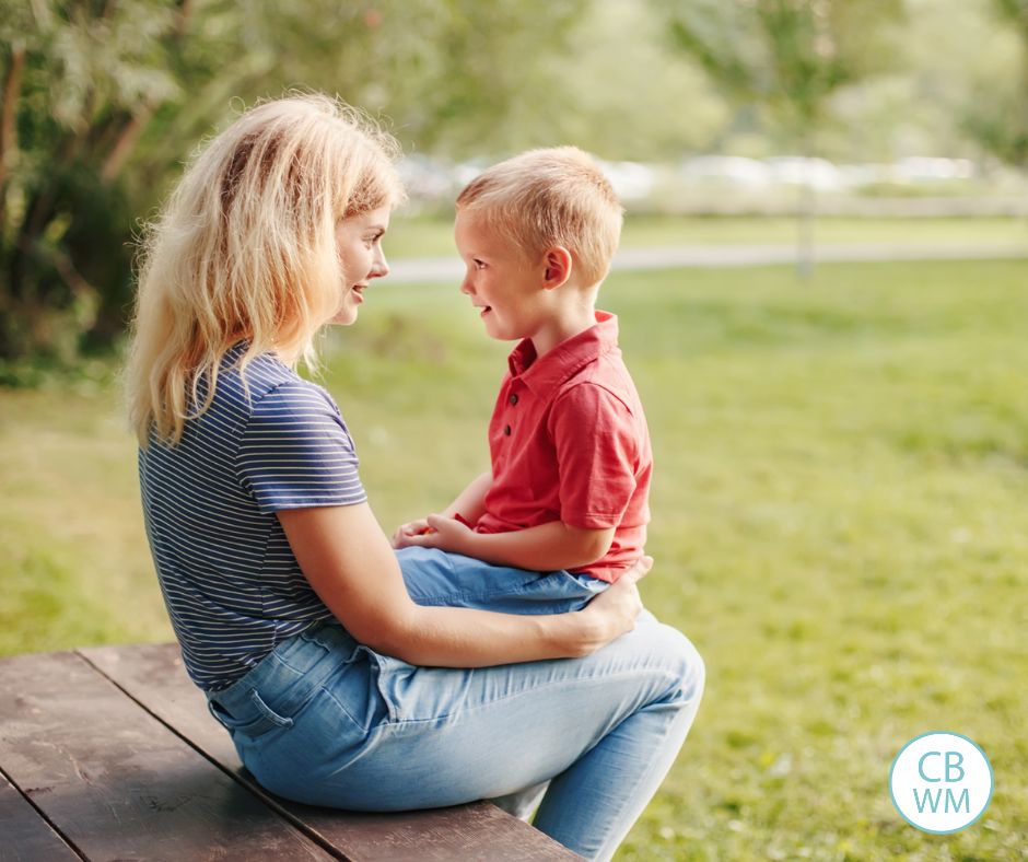 mom sitting on a wood porch talking to her son on her lap