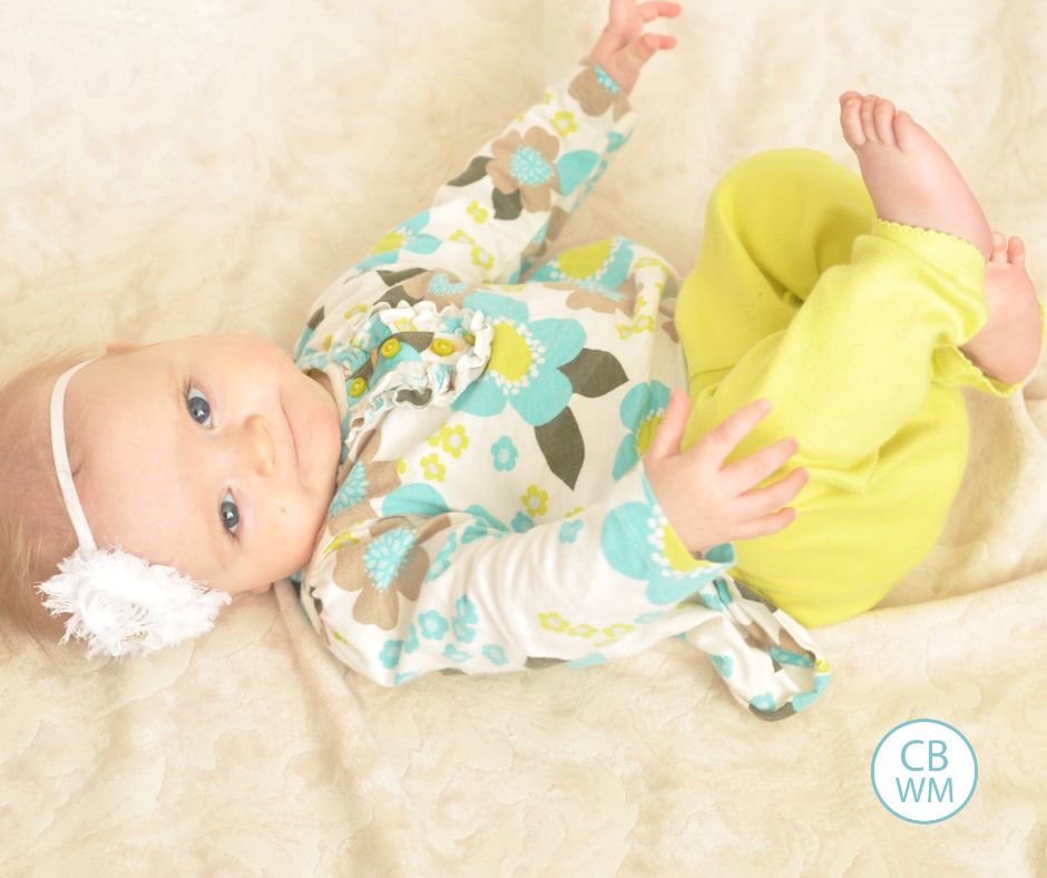 6 month old Brinley laying on her back looking up at the camera.