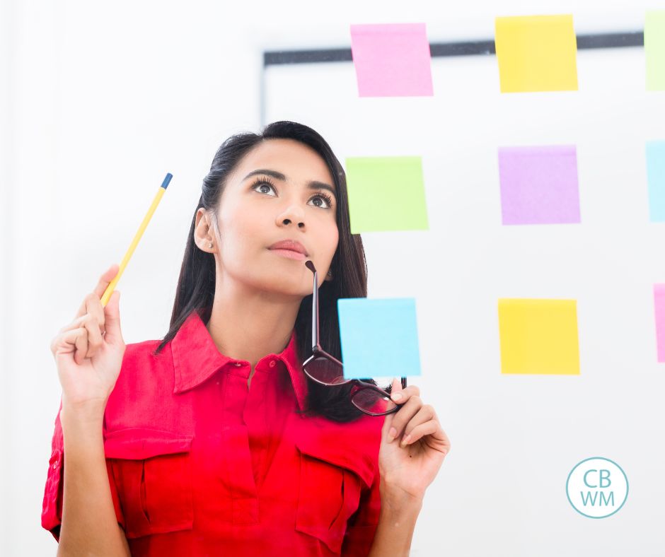 woman looking at sticky notes on a wall