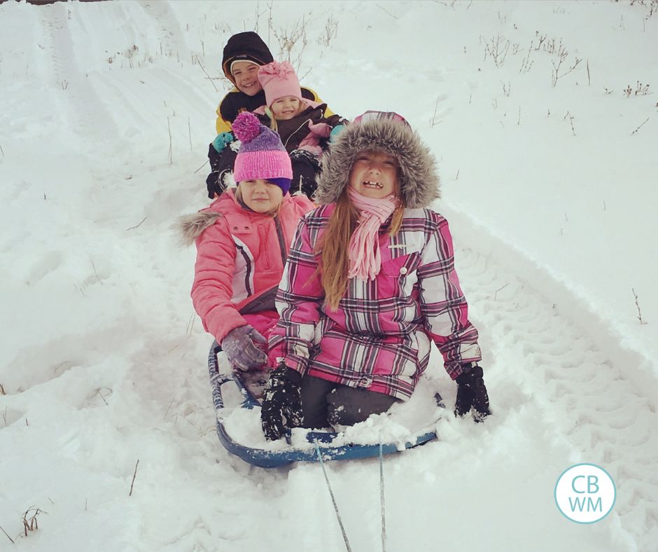 All 4 kids sledding in the snow