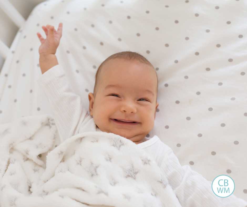 Baby with arm in the air and a big smile