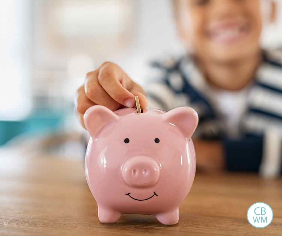Child putting coins in a piggy bank