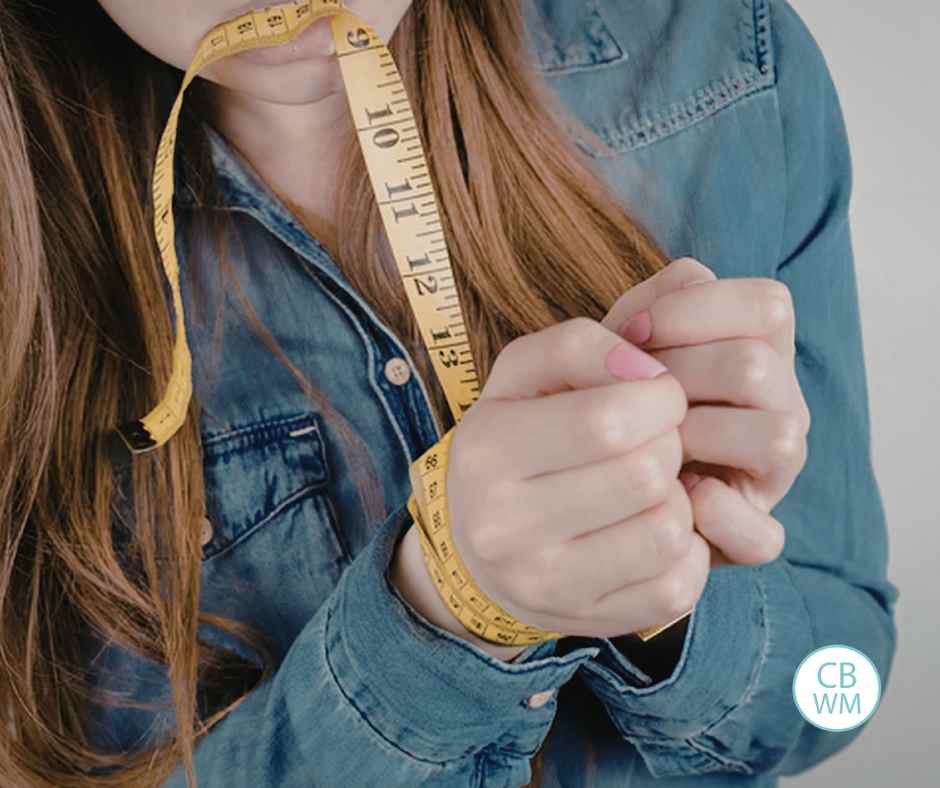 Woman with a measuring tape cuffing her hands