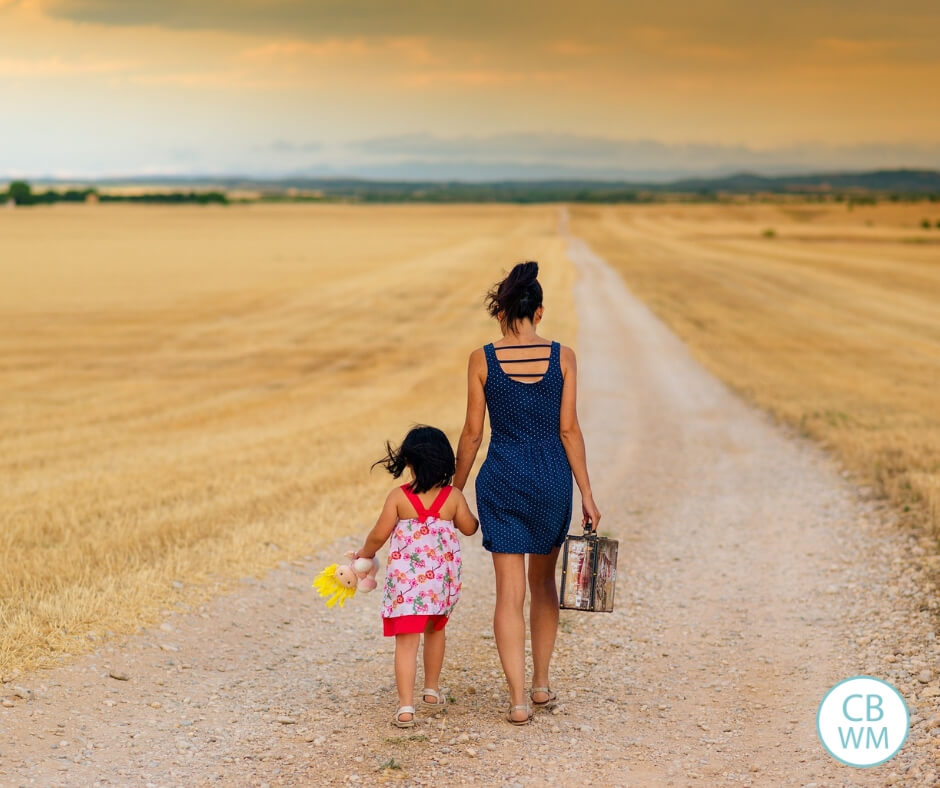 mother and daughter walking along a dirt road