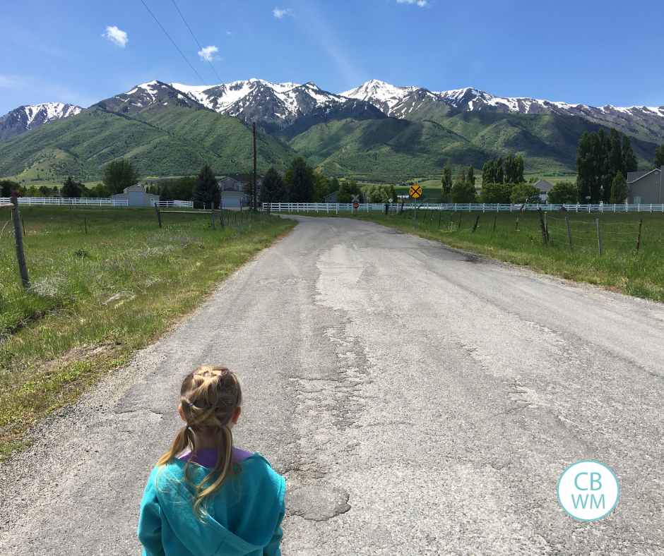 Brinley on a walk. She is walking toward beautiful, large mountains