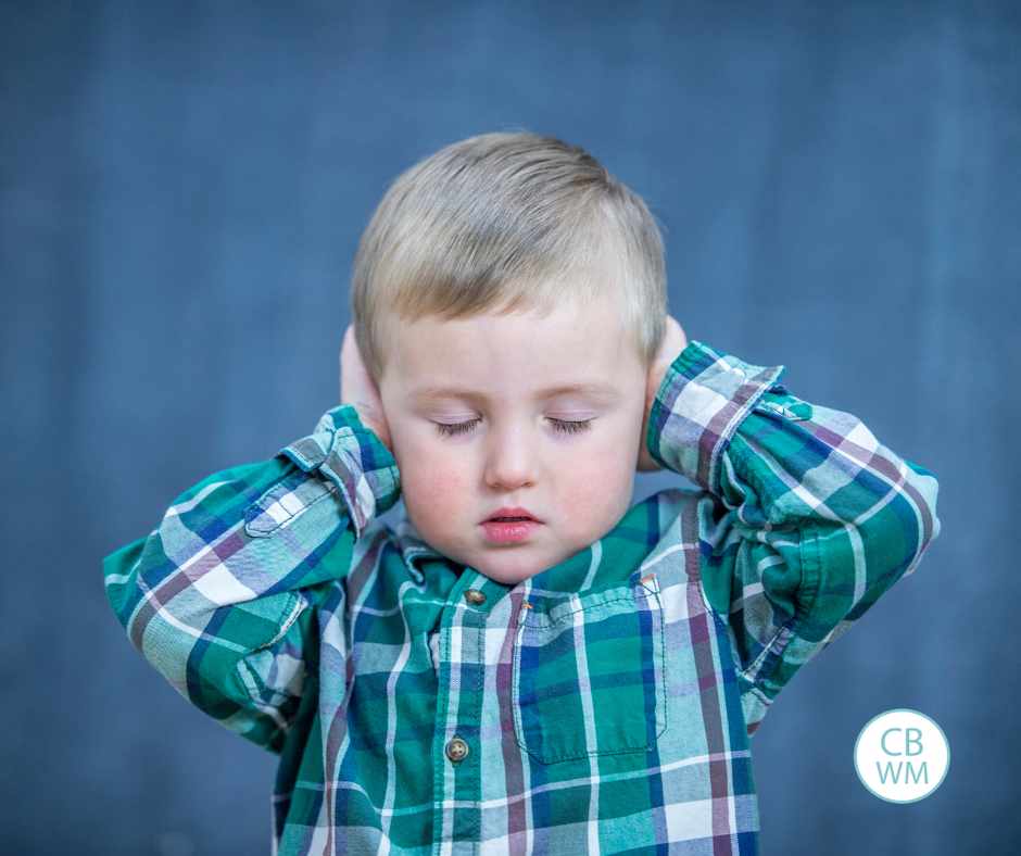 Preschooler covering his ears