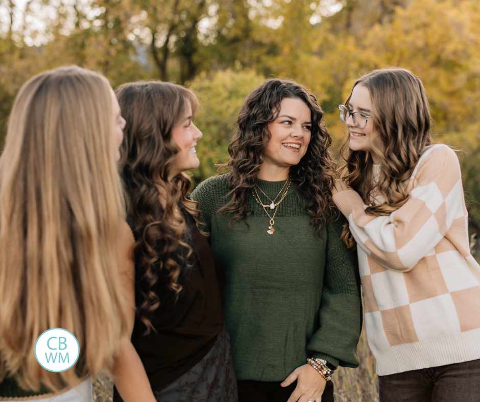 Valerie with her three daughters looking at each other and smiling