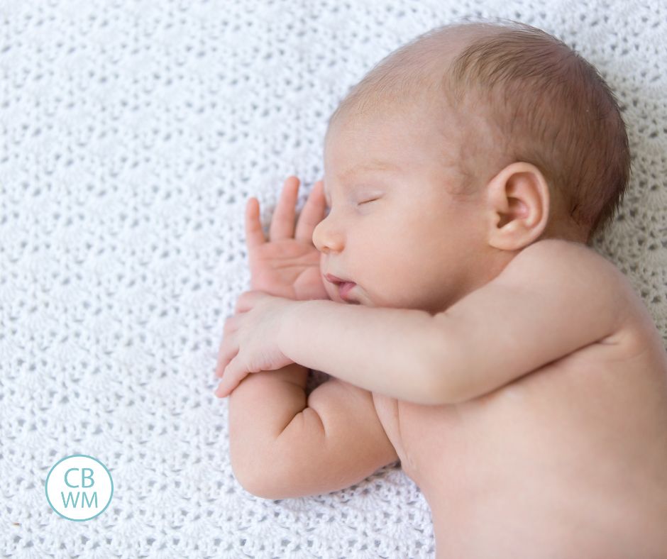 Baby sleeping on their side on a white crocheted blanket