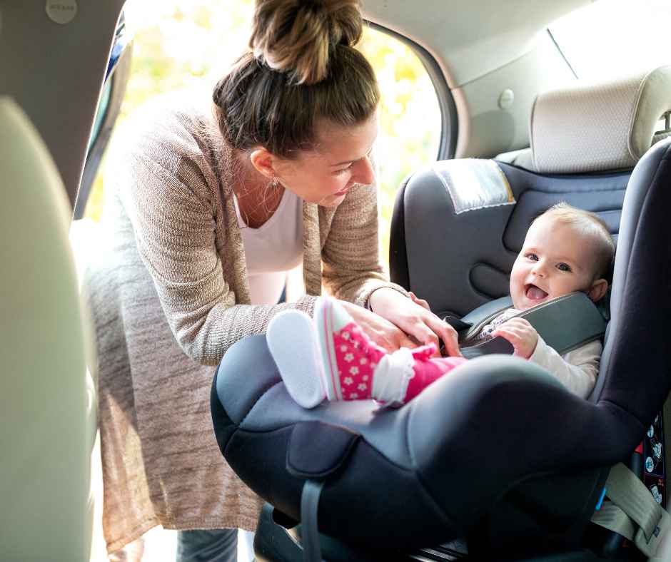 Child being buckled into the car seat by her mom