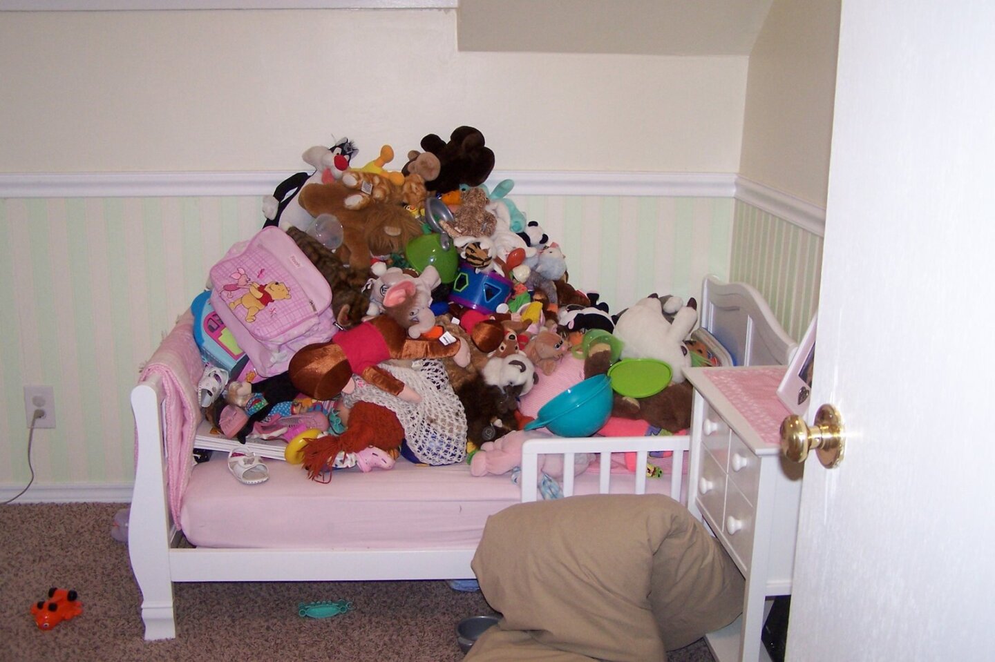 Pile of toys on a toddler bed