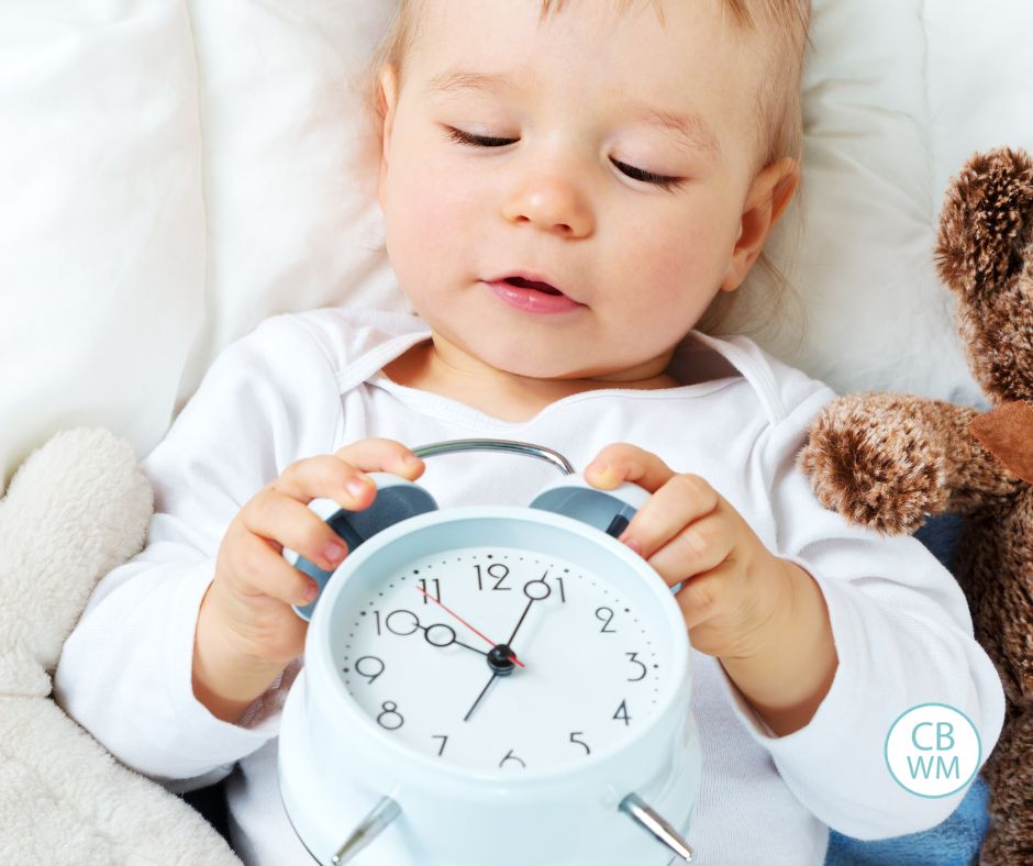 Baby holding an alarm clock