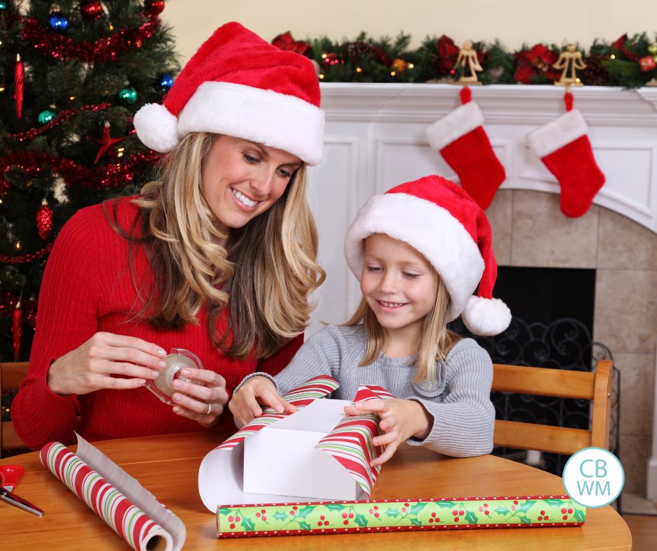 Mom and child wrapping Christmas gifts together