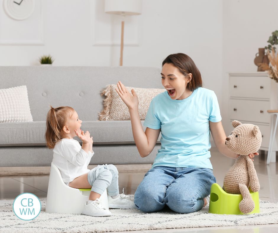 Mom with her child who is sitting on a potty chair