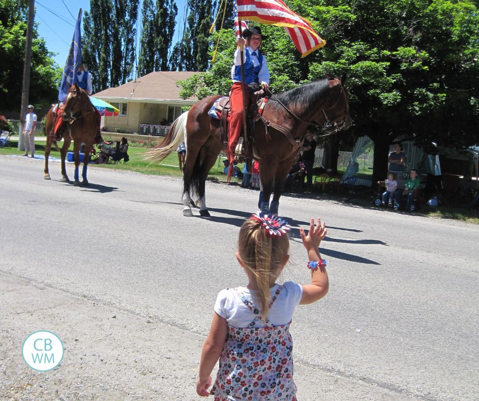 Kaitlyn at a parade looking at a horse in a parade