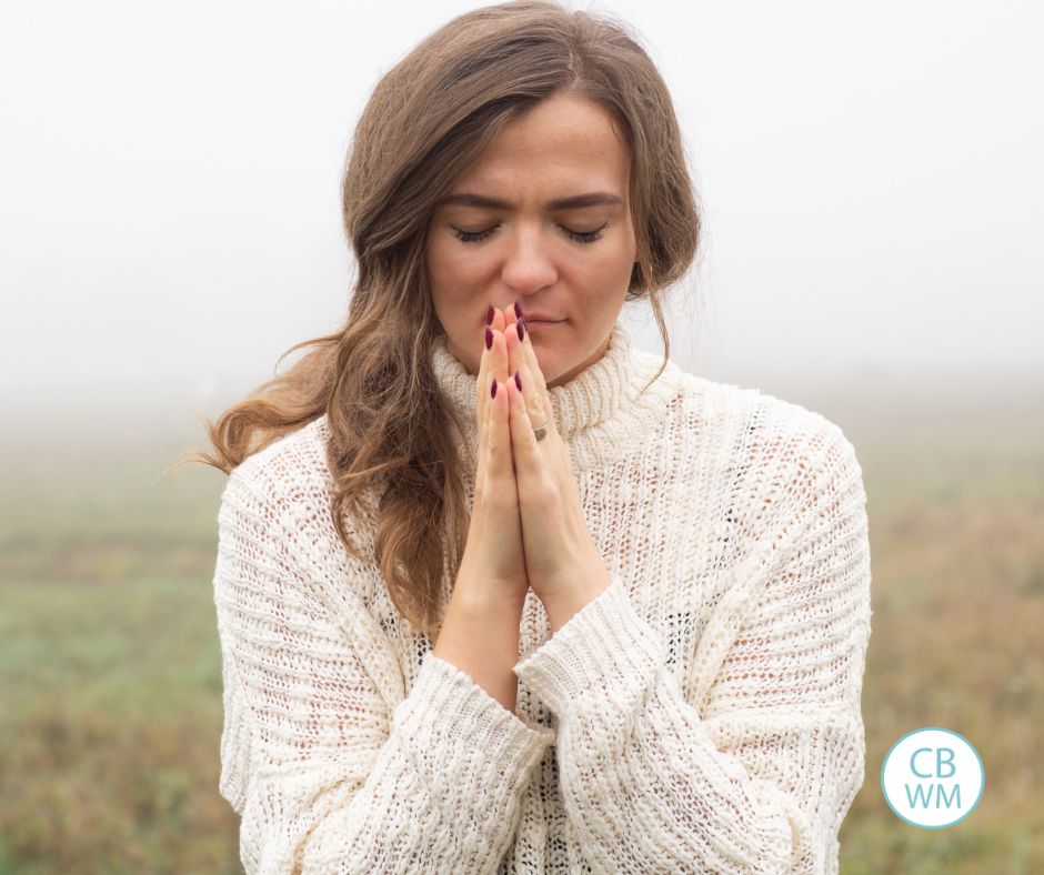Woman deep in comtemplation with her hands clasped in gratitude