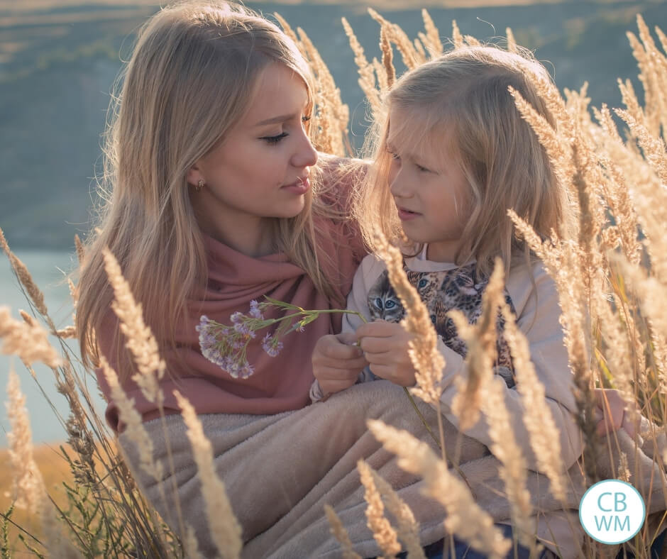 Mother and daughter sitting in a wheat field