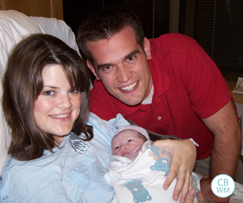 A newborn baby with her mother and father in the hospital