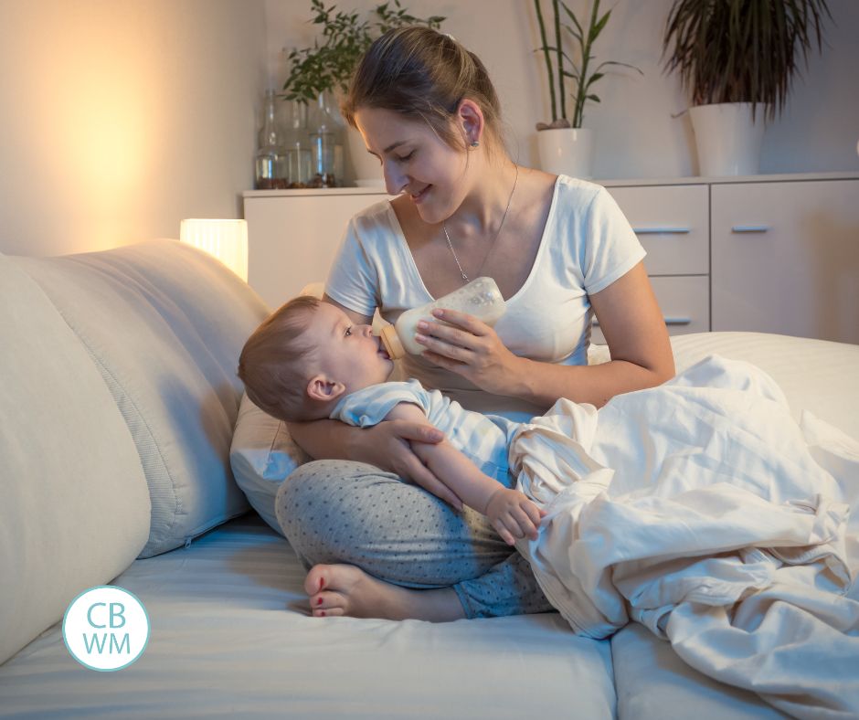 Mom feeding baby a bottle in the night