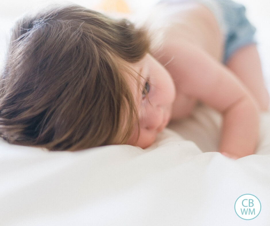 Baby or toddler laying on a white surface