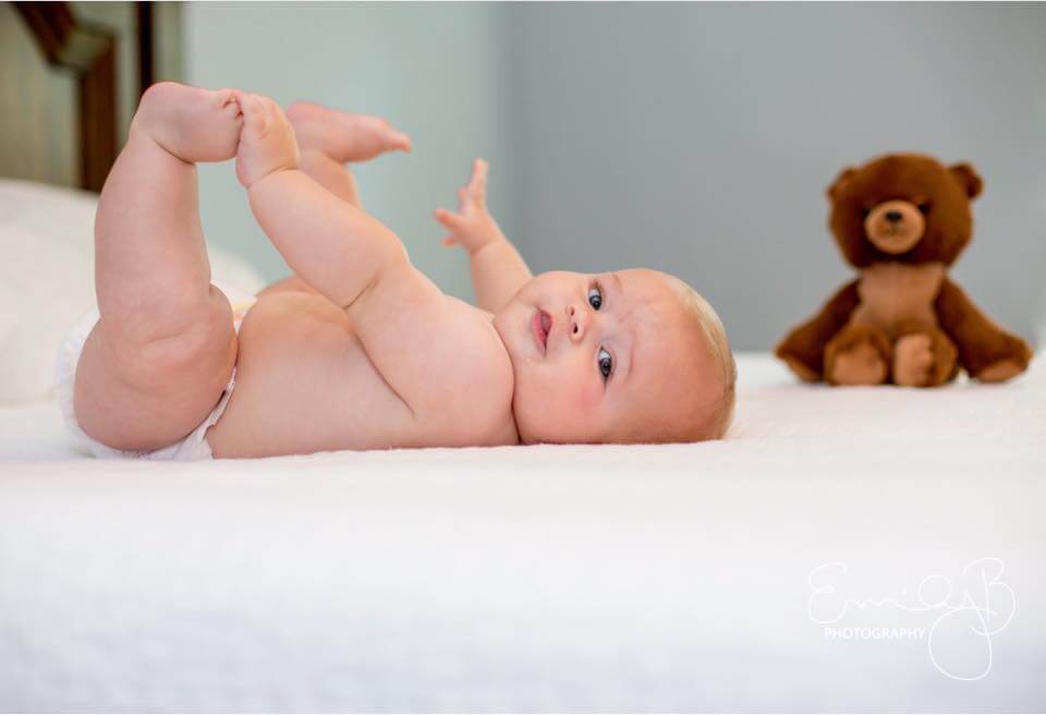 9 month old baby on a bed