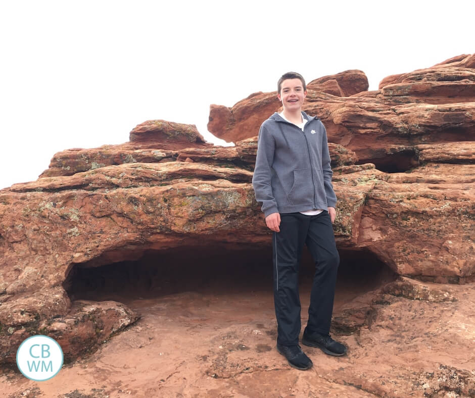 Teenage boy standing on red rock