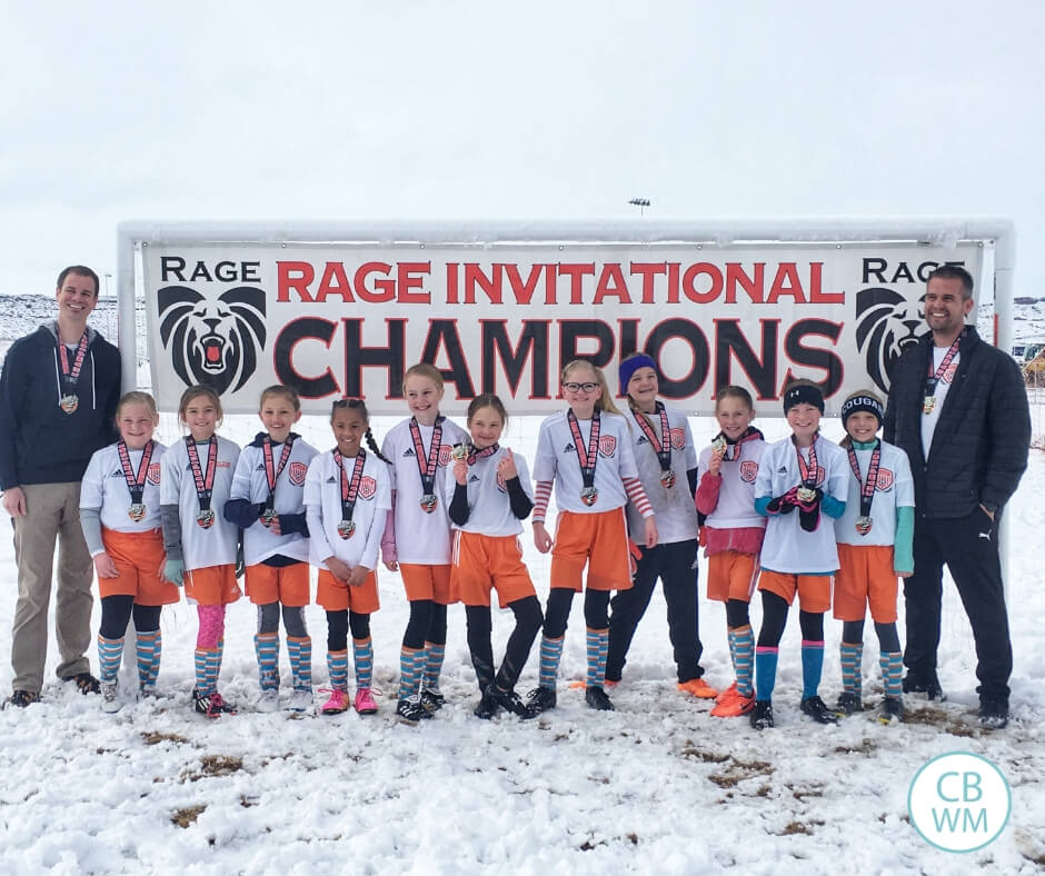 Soccer team standing in front of a championship sign