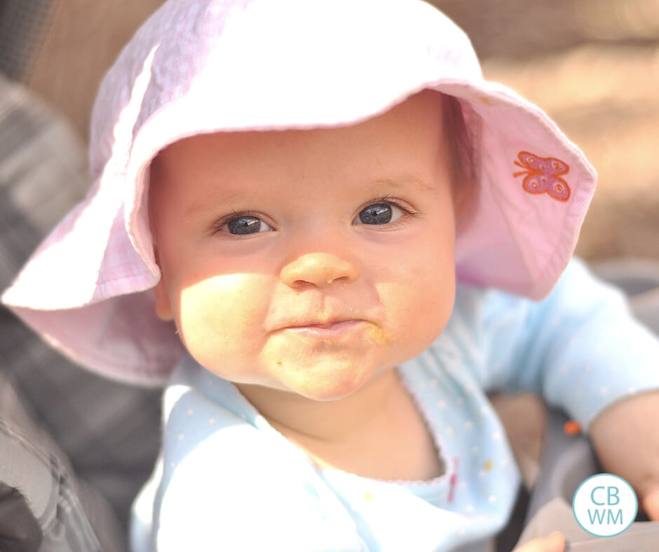 Baby wearing sunhat and looking smug