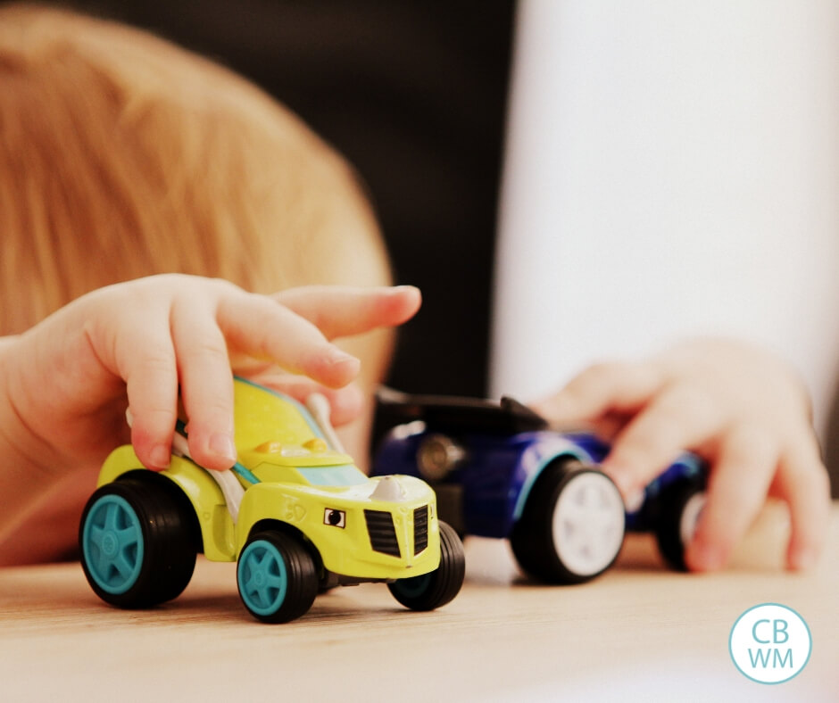 Child playing with toy cars at the table