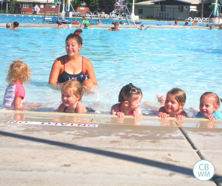 Children taking swimming lessons in an outdoor pool