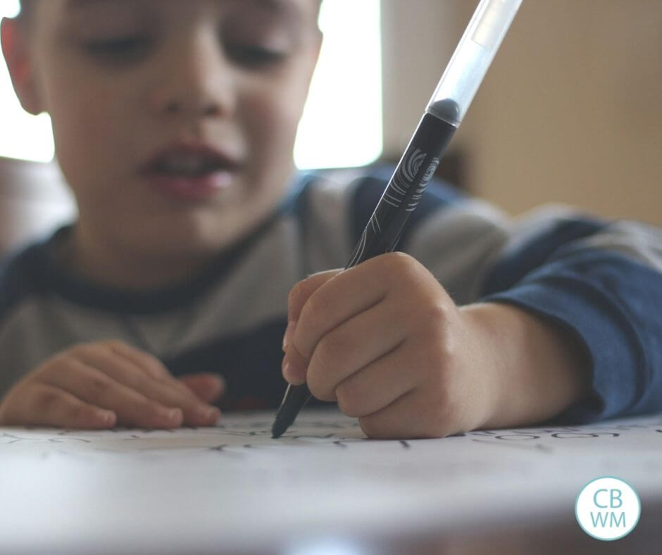 Child writing on paper at home