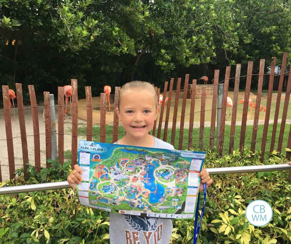 Brinley in front of the flamingos holding a sea world map