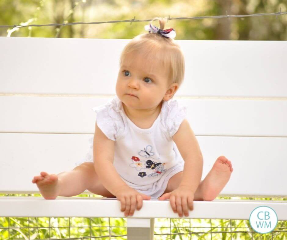 Brinley sitting on a bench at 11 months old