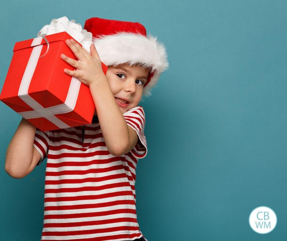 Child holding gift wrapped in red