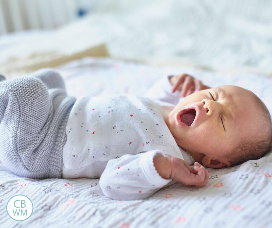 Baby yawning on a bed