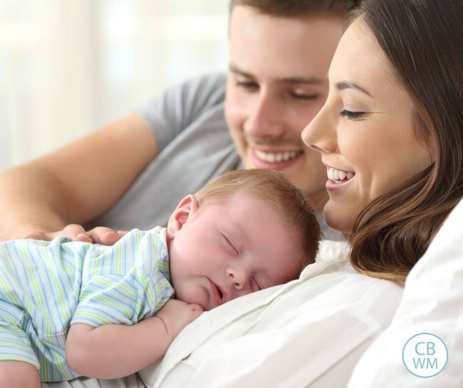 Baby sleeping on mom's chest while dad watches